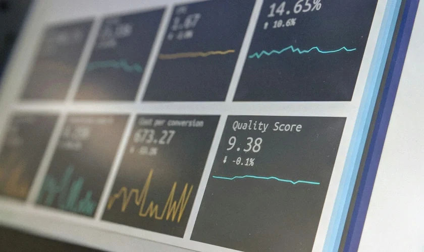 A close-up of a computer screen displaying various data analytics dashboards, each showing different graphs, percentages, and scores, including a quality score of 9.38 and several line charts with fluctuating data.