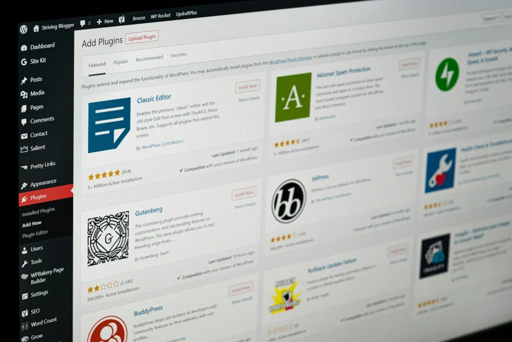 Ein Computerbildschirm mit dem WordPress-Dashboard und der Seite "Plugins hinzufügen", auf der eine Liste der verfügbaren Plugins wie Classic Editor, Gutenberg, BuddyPress und andere angezeigt wird.